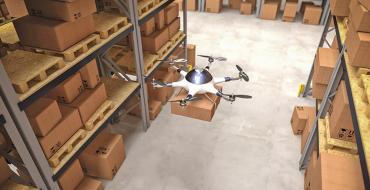 Drone volando y cargando un paquete por una bodega